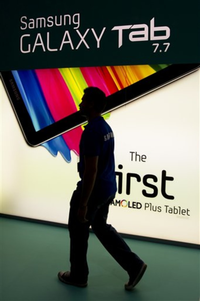 A man walks by an ad display for the Samsung Galaxy Tab at the Samsung booth at the IFA, one of the world's largest trade fairs for consumer electronics and electrical home appliances in Berlin, Germany. 